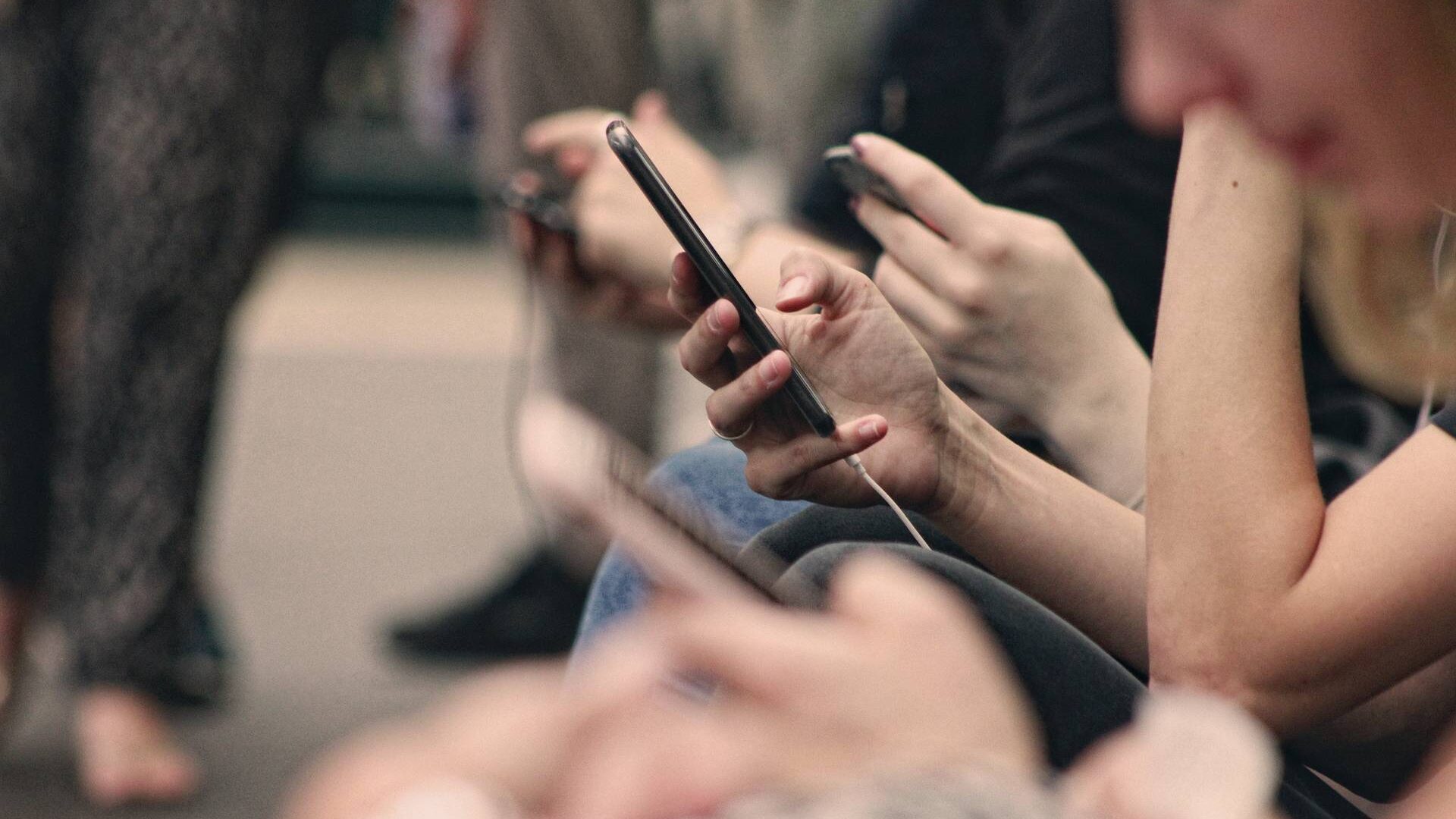 Ihmisiä mobiililaitteet käsissään